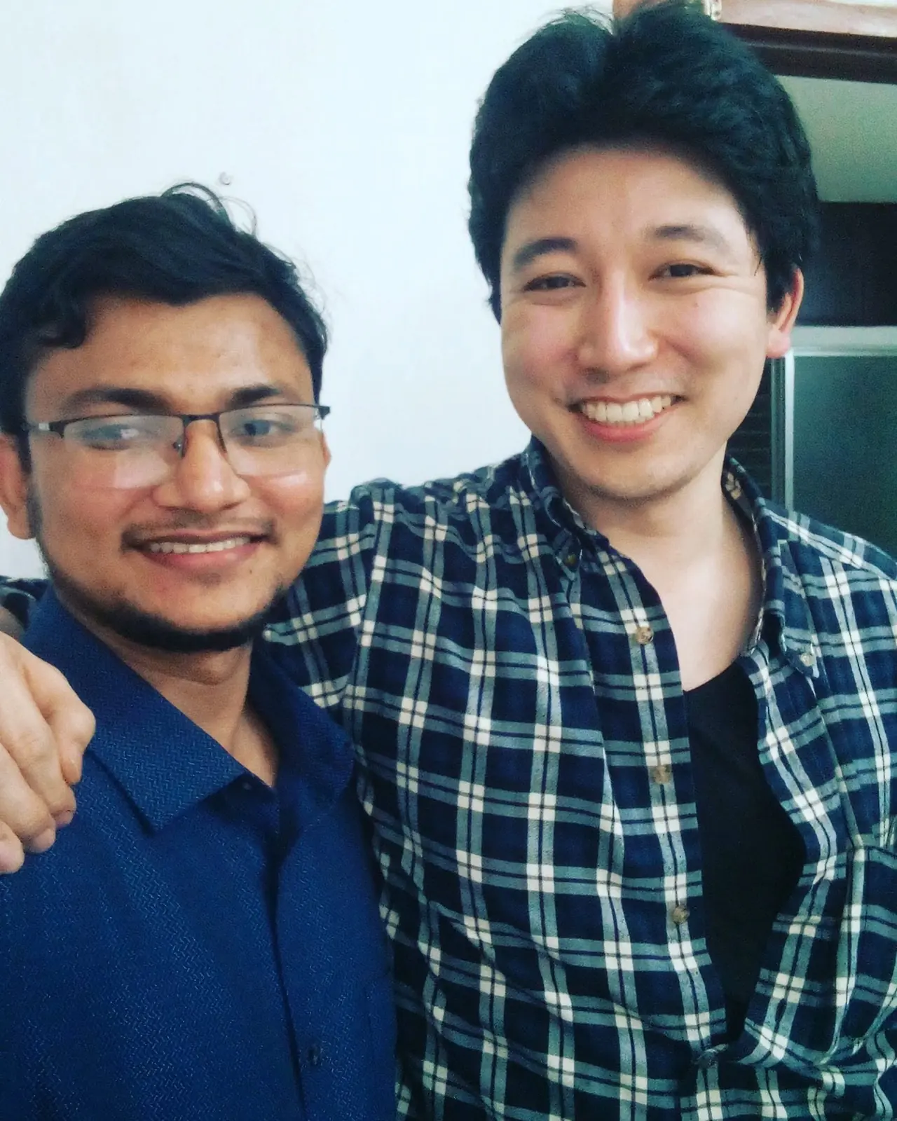 Two colleagues smiling for a close selfie, one of them a Japanese partner