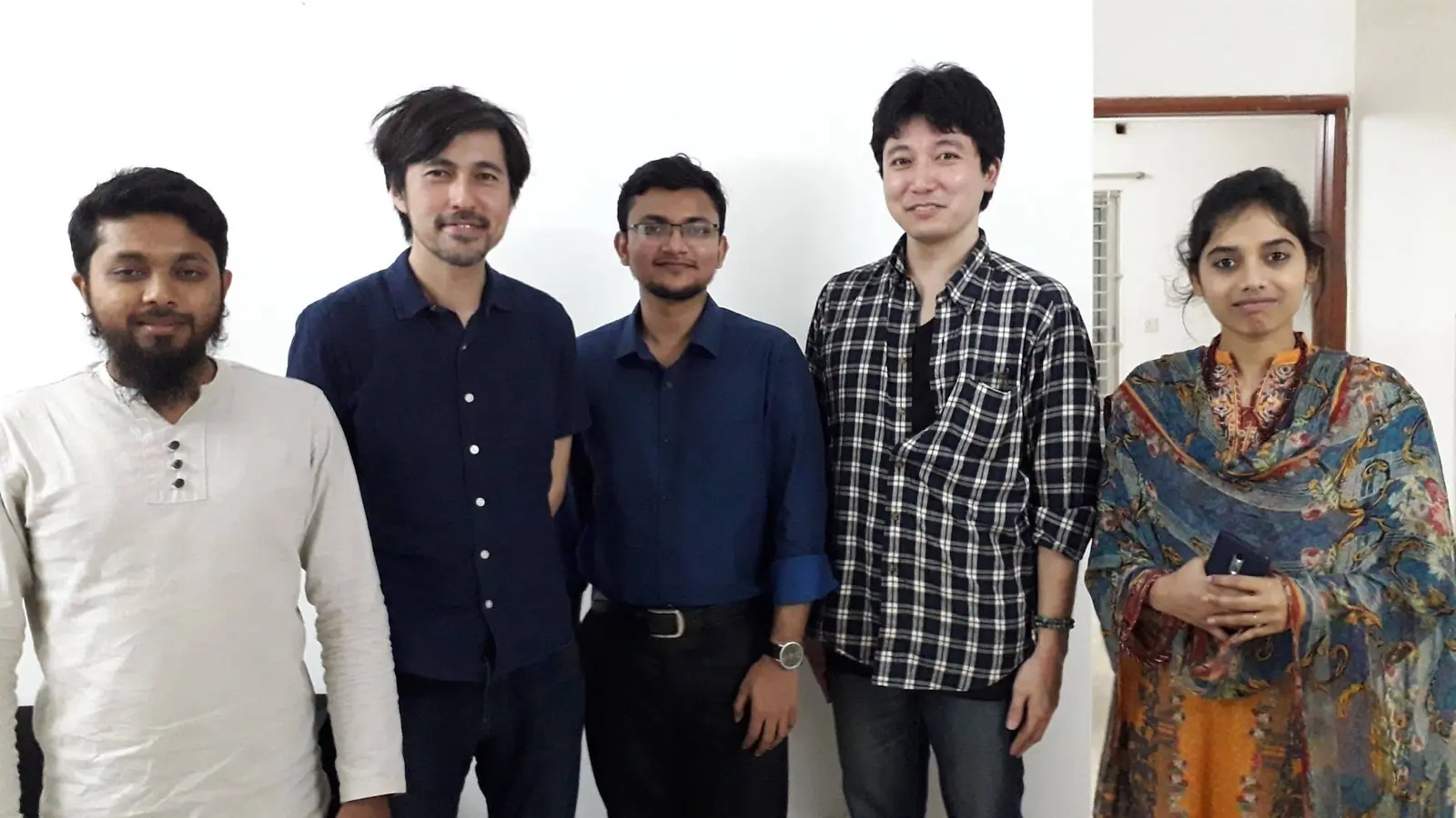 Colleagues lined up together in the office, including a Japanese client partner joining the team